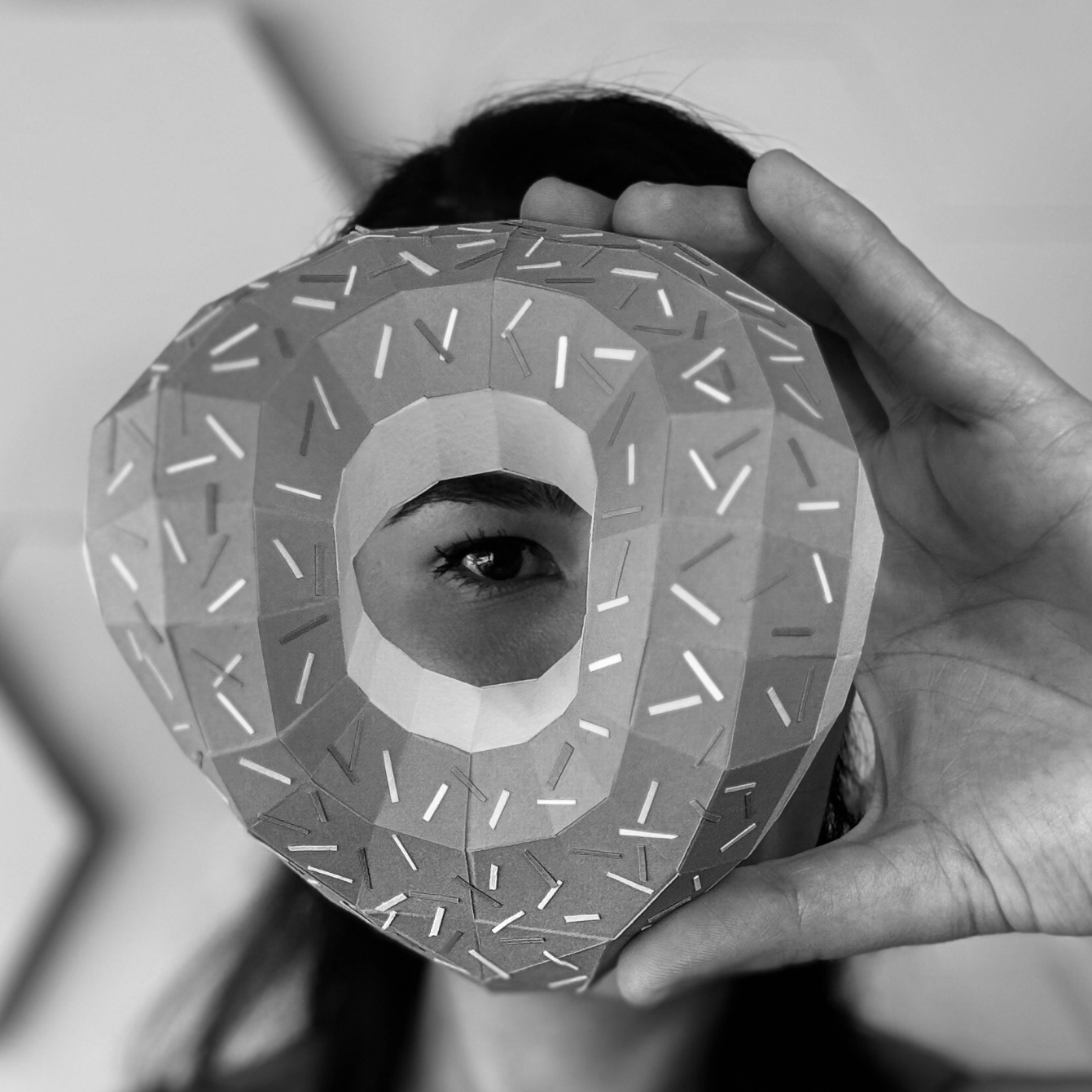 Fernanda Micocci tenant une sculpture de papier circulaire devant son visage